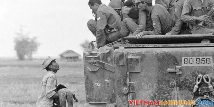 Hình ảnh người cha ôm xác con nhìn chằm chằm về phía toán lính biệt kích của quân đội VNCH trên xe thiết giáp, ngày 19/3/1964.