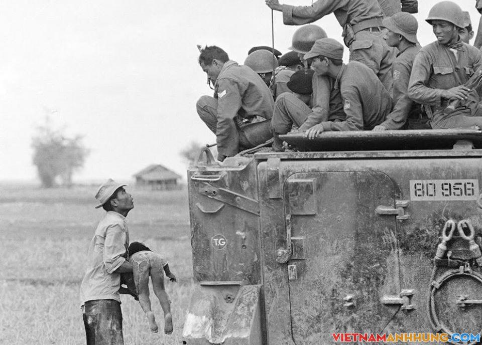 Hình ảnh người cha ôm xác con nhìn chằm chằm về phía toán lính biệt kích của quân đội VNCH trên xe thiết giáp, ngày 19/3/1964.